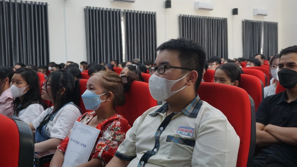 Phụ huynh và học sinh lắng nghe thầy hiệu trưởng tư vấn về chương trình học. Ảnh: NGUYỄN QUYÊN.