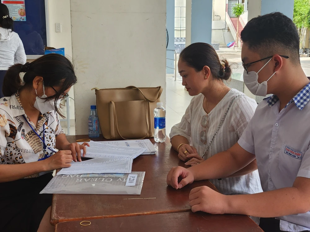 Bùi Minh Khôi cùng với mẹ đến mua hồ sơ nhập học và lắng nghe tư vấn về việc chọn lựa tổ hợp môn lớp 10 tại Trường THPT Bùi Thị Xuân, quận 1. Ảnh: NGUYỄN QUYÊN