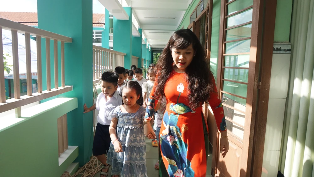 Cô giáo dẫn học trò tham quan các phòng học