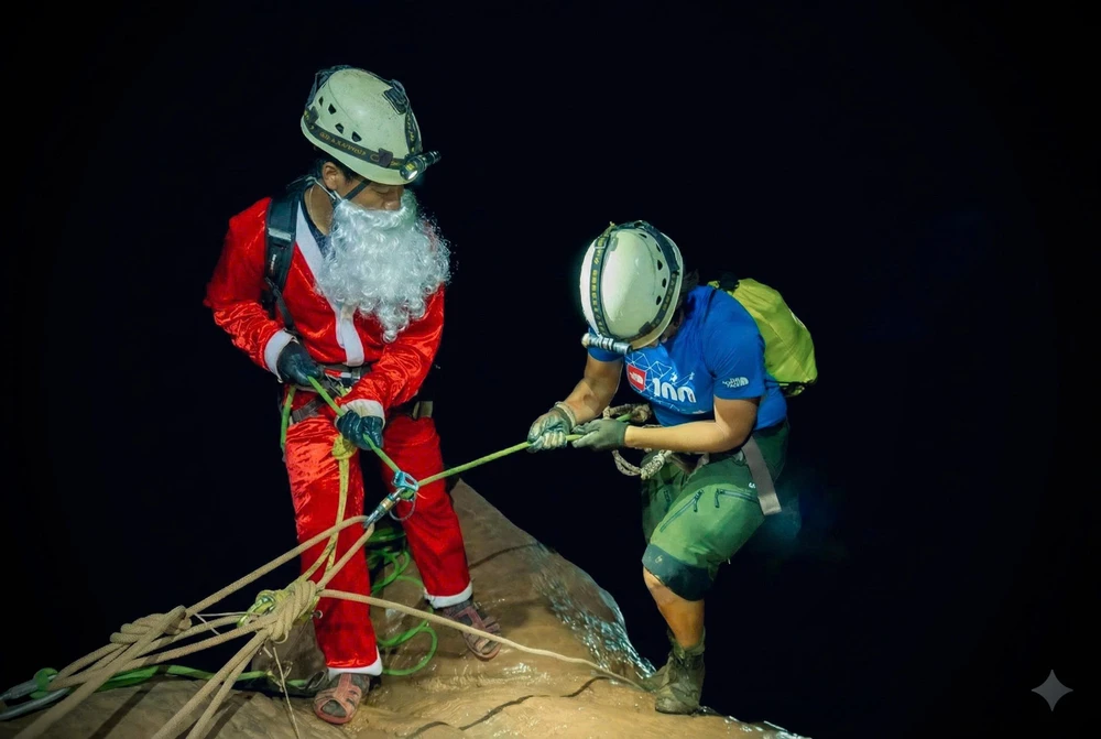 Ông già Noel hỗ trợ du khách đu dây xuống hang Pygmy. Ảnh CTV.jpg
