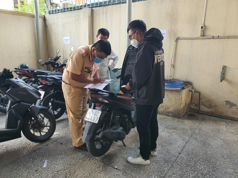 Một cán bộ công an đang thực hiện công tác xét xe cho người dân.