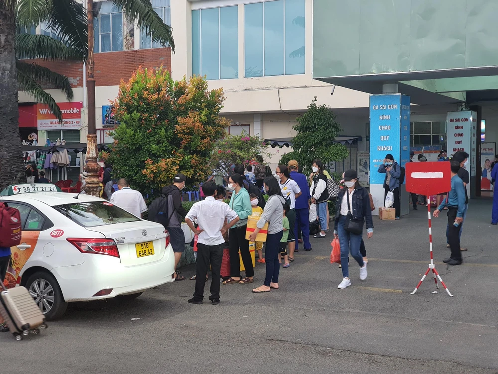 Hành khách đứng chờ xe hoặc người thân đến đón. Ảnh: THY NHUNG Hành khách đứng chờ xe hoặc người thân đến đón. Ảnh: THY NHUNG