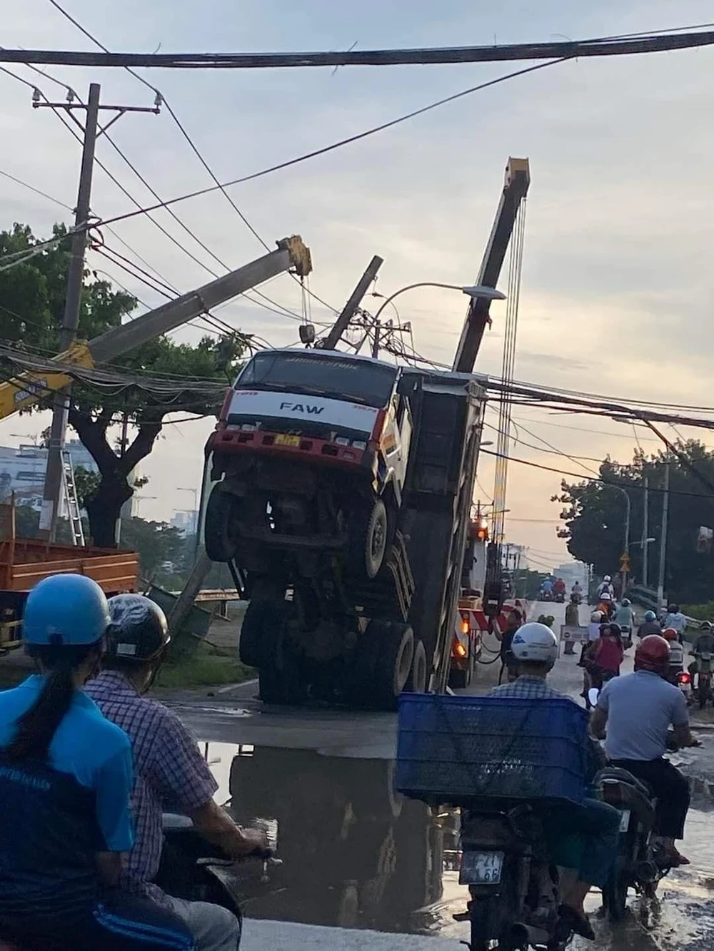 Nguyên nhân do thùng xe ben vẫn còn đang nâng nên vướng vào bó cáp viễn thông. Ảnh: NGUYỄN YÊN