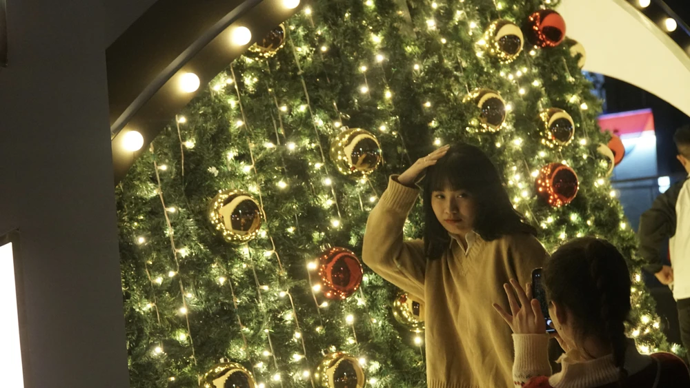 Các bạn trẻ cùng nhau check in bên cây thông Noel