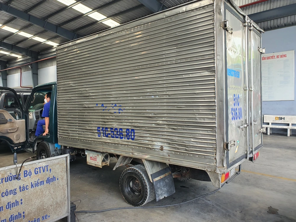 Kiểm định viên đang kiểm tra khí thải xe tải. Ảnh: THY NHUNG