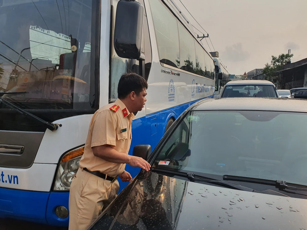 CSGT đang kiểm tra ngày hết hạn kiểm định của các loại xe. Ảnh: THY NHUNG