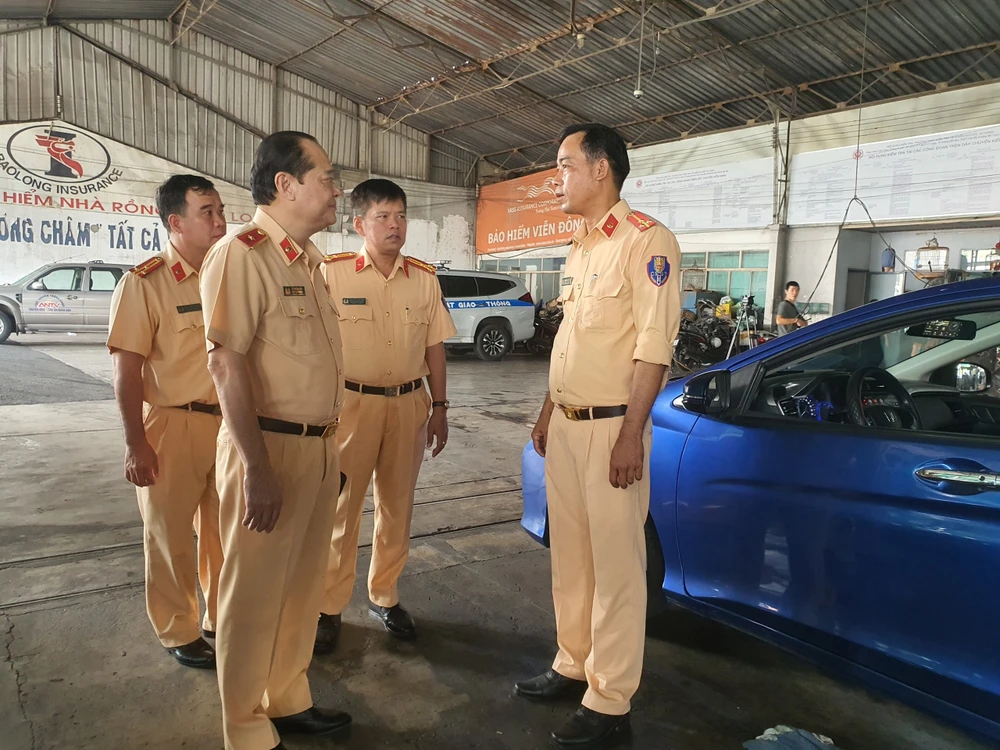 Thiếu tướng Lê Xuân Đức hỏi thăm, động viên cán bộ hỗ trợ đăng kiểm cho TTĐK 50-03S. Ảnh: THY NHUNG