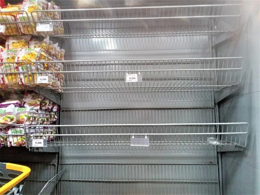 Ba kệ hàng mì gói trống trơn sản phẩm chỉ còn bảng giá.