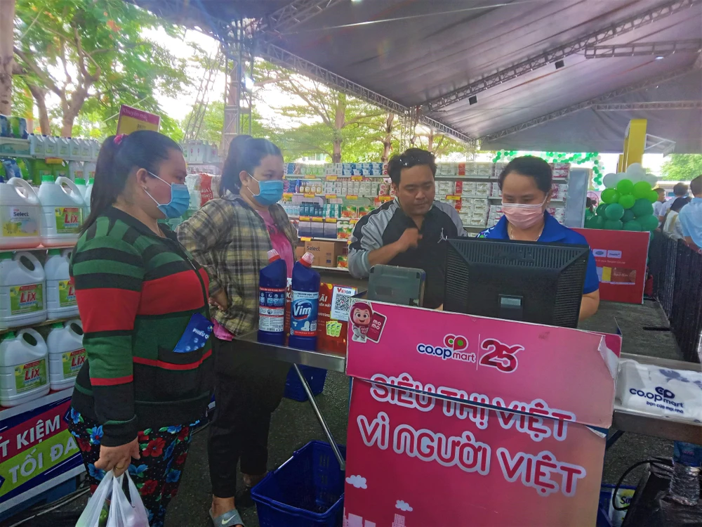 Người lao động mua sắm tại Chợ phiên không tiền mặt ở Khu chế xuất Tân Thuận quận 7. Ảnh: TÚ UYÊN