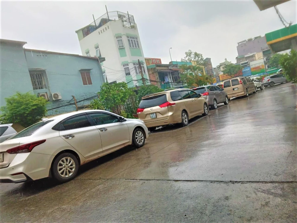 Gần 10 chiếc ô tô xếp hàng chờ đổ xăng do cửa hàng này chỉ còn một trụ bơm còn xăng.