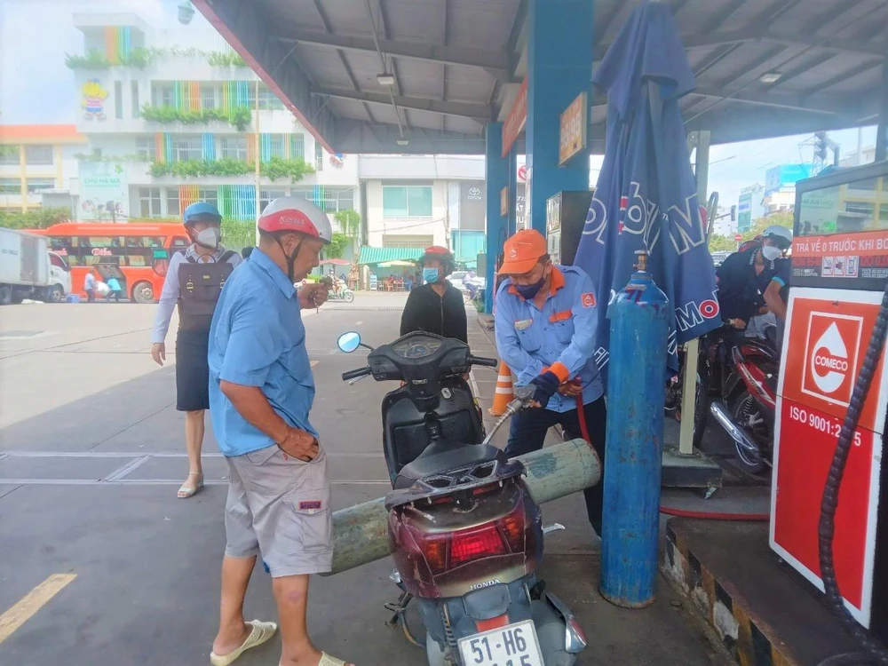 Nhân viên cửa hàng hỗ trợ đổ ngay xăng cho vị khách phải chở bình oxy đi cấp cứu
