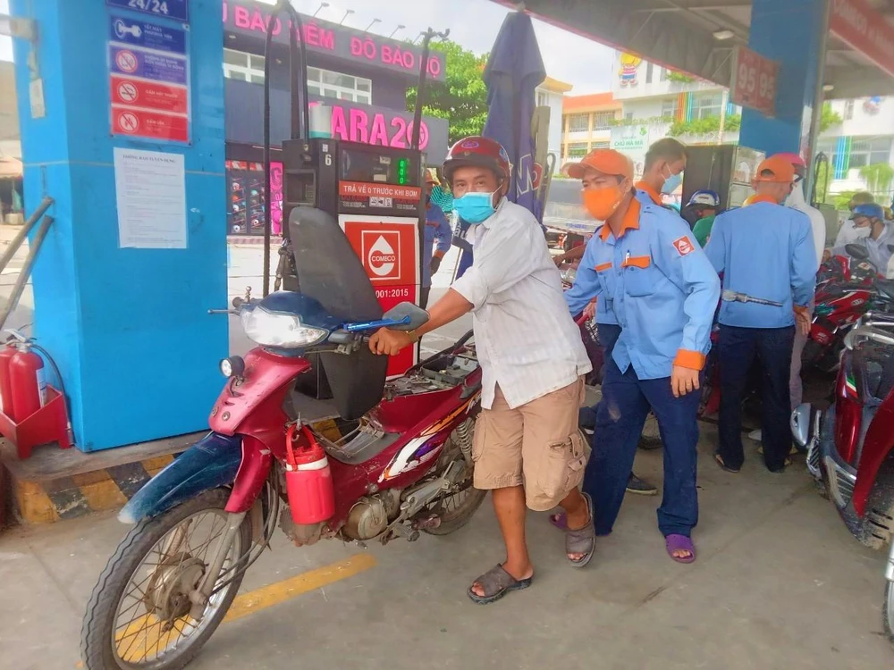 Nhiều xe chưa kịp đậy nắp bình xăng, nhân viên cửa hàng hỗ trợ khách trong trật tự