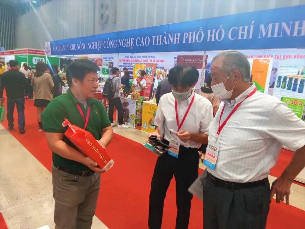 Khách tham quan quan tâm tìm hiểu sản phẩm gạo của doanh nghiệp