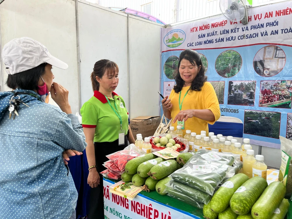 Một khách hàng mua các loại củ quả đang trưng bày tại sự kiện