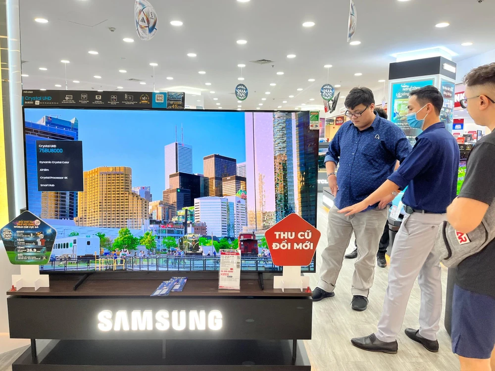 Khách hàng đang tìm hiểu các dòng tivi đang bày bán tại siêu thị điện máy.