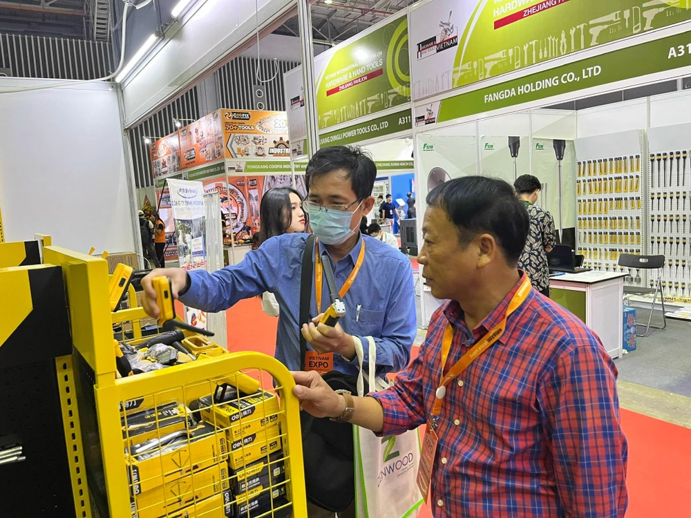 Khách tìm hiểu dụng cụ làm vườn, dụng cụ xây dựng...tại một gian hàng.