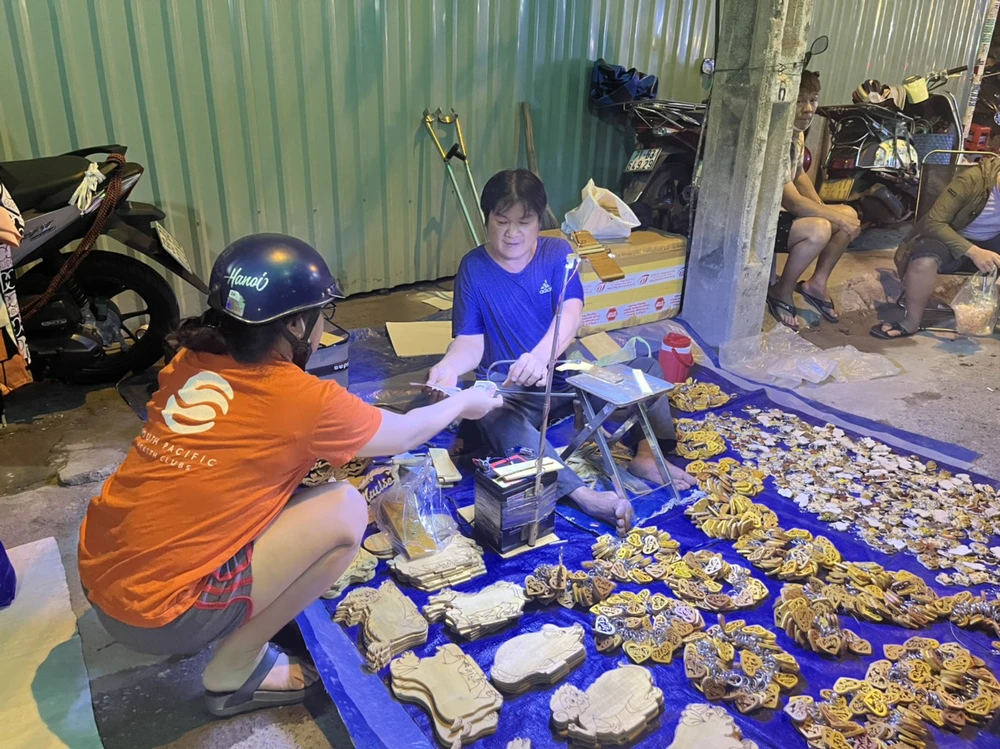 Người dân có thể yêu cầu khắc tên trên các đồ lưu niệm bằng gỗ