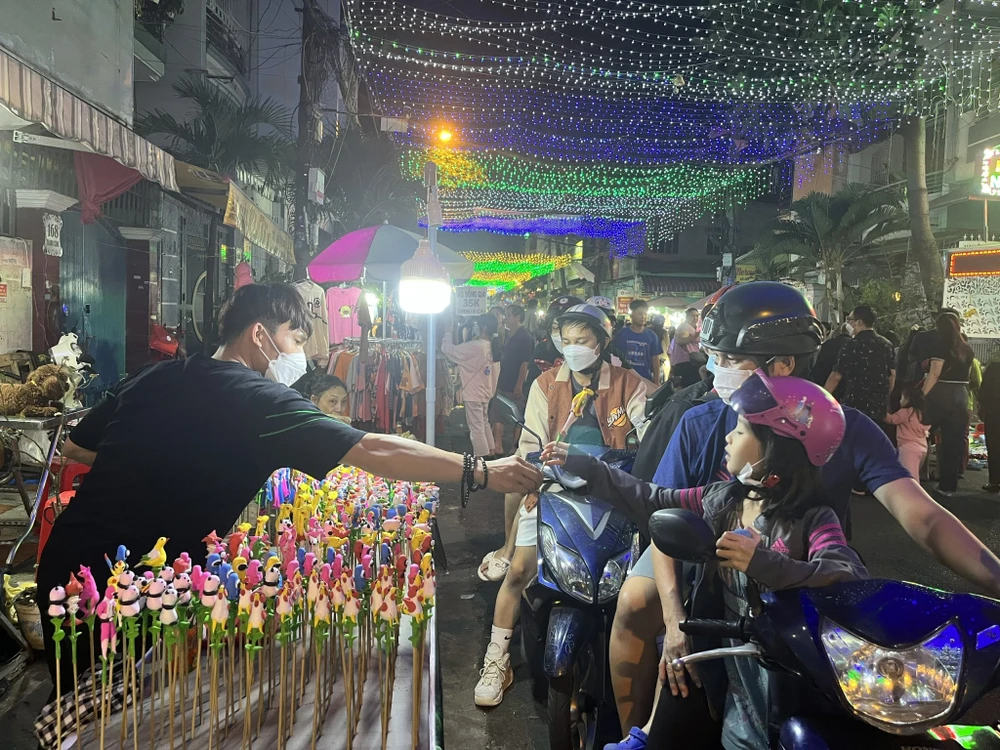 Một gia đình mua tò he trong lúc đi chơi Giáng sinh