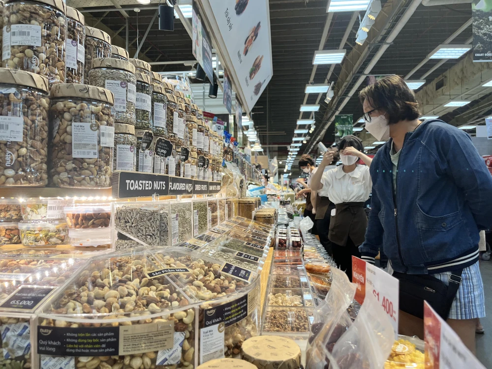 Người tiêu dùng quan tâm đến các loại hạt hướng dương, hạt dẻ...đang khuyến mãi ở siêu thị. Ảnh: TÚ UYÊN