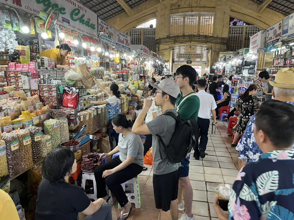 Du khách vừa dùng thử cà phê vừa tìm hiểu các loại hạt bày bán ở chợ Du khách vừa dùng thử cà phê vừa tìm hiểu các loại hạt bày bán ở chợ