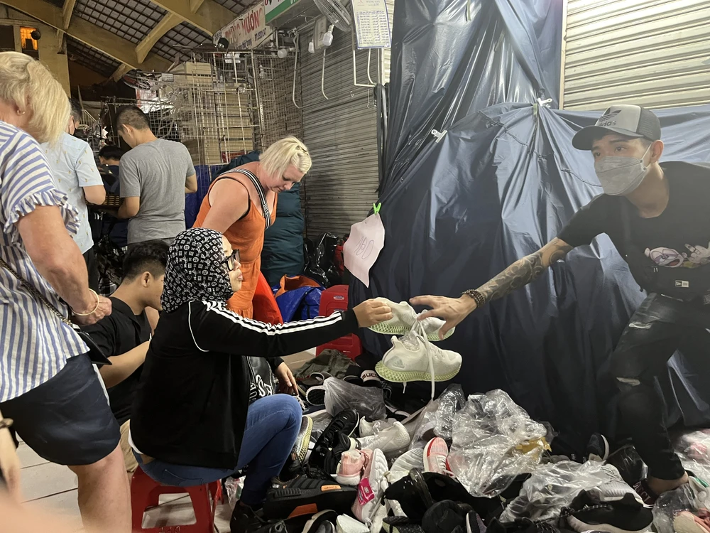 Du khách tranh thủ mua giày đang được giảm giá còn 250.000 đồng/đôi.