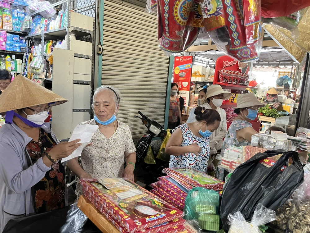 Bên trong lồng chợ, một số người dân mua các loại áo giấy cúng ông Táo, cúng giao thừa.