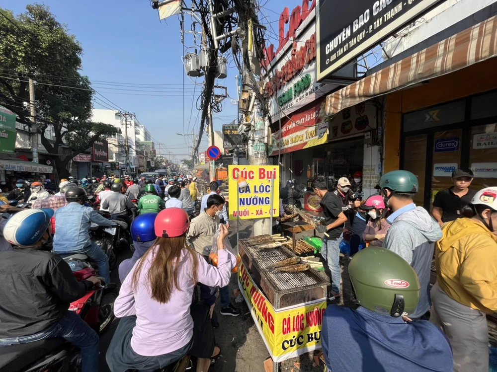 Điểm bán này hết cá lóc lớn, người dân đang chờ mua cá lóc đang nướng giá 220.000 đồng/con