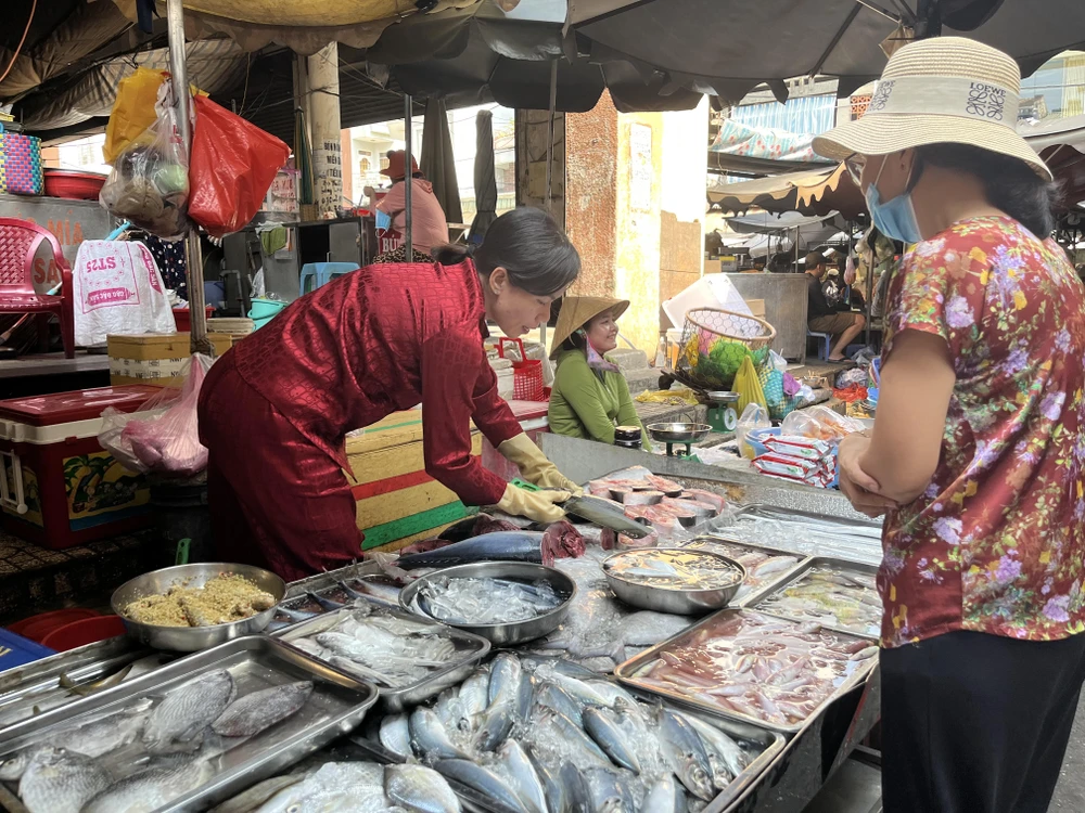 Người tiêu dùng đang mua cá tại chợ. ẢNH: TÚ UYÊN