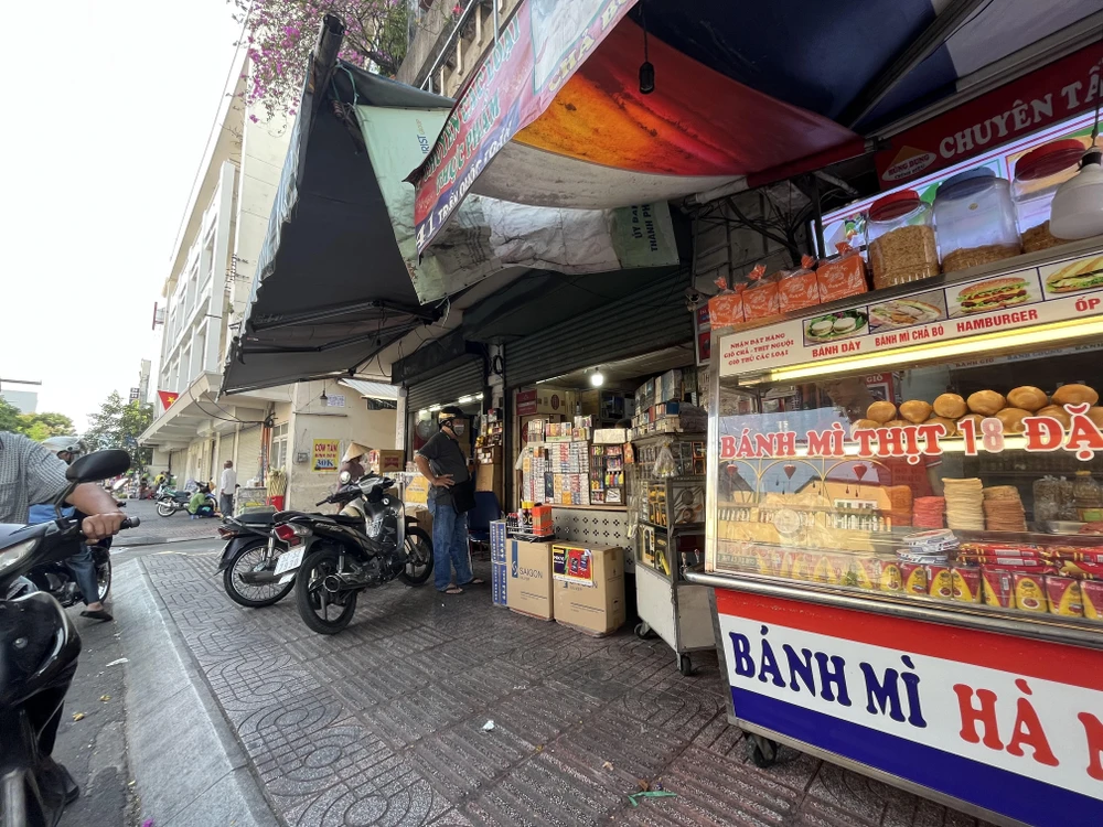 Người dân đang mua thuốc lá tại con đường chuyên bán thuốc lá quận 3. ẢNH: TÚ UYÊN