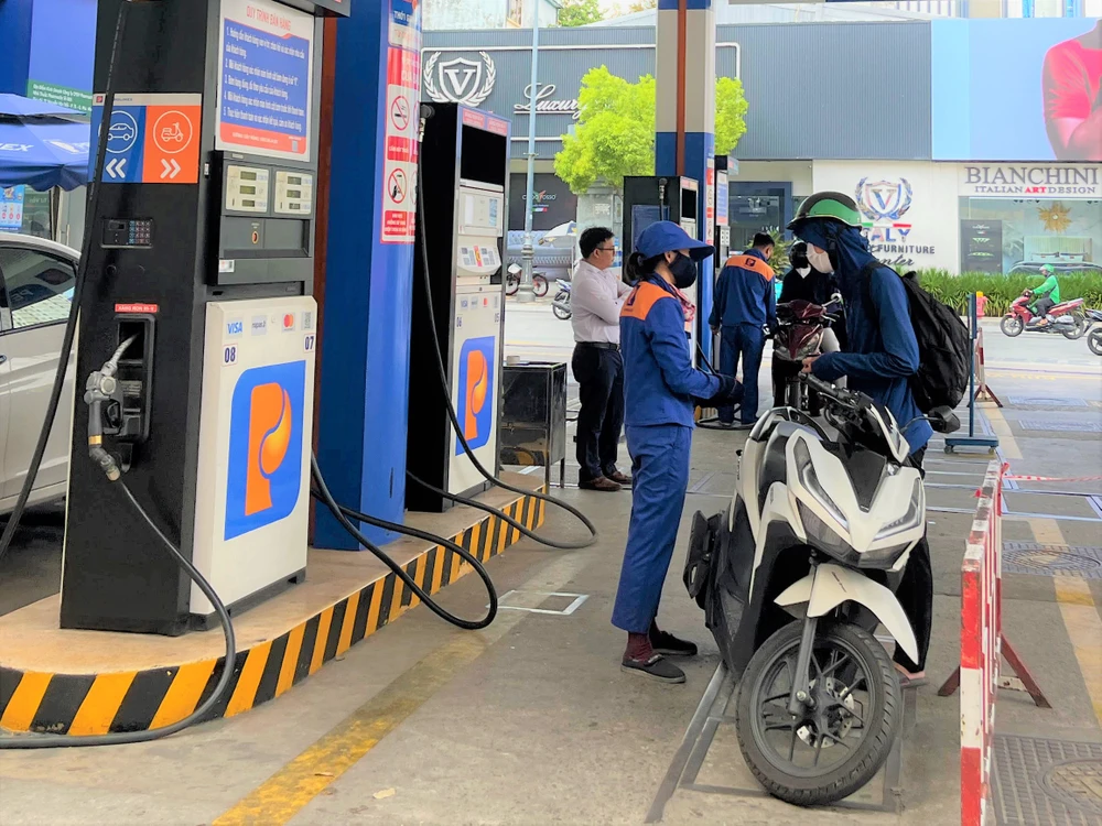 Người dân đổ xăng tại cửa hàng quận Phú Nhuận. ẢNH: TÚ UYÊN