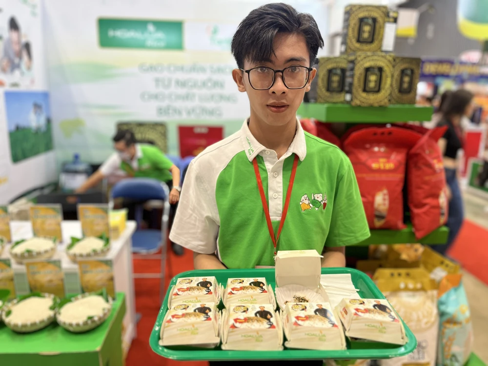 Khách tham quan dùng thử cơm nấu chín từ gạo Hoa Lúa ST 25 giá 200.000 đồng/5kg