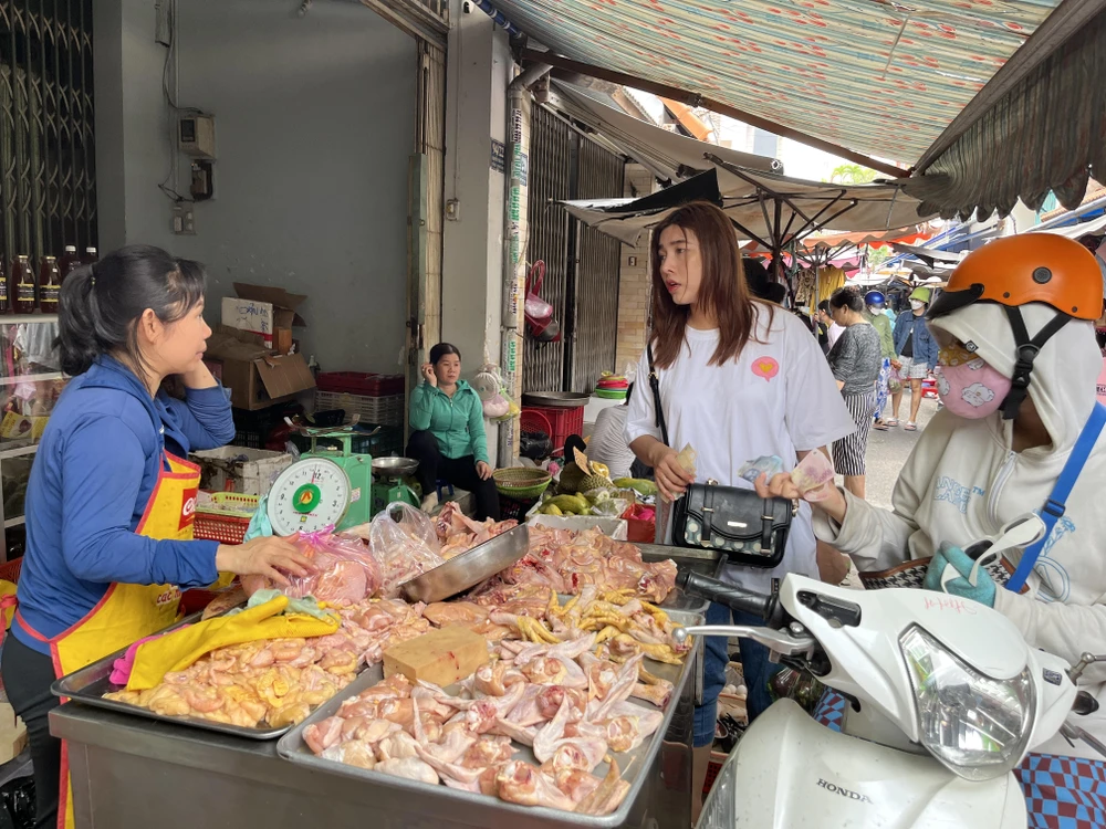 Người tiêu dùng mua thịt gà tại chợ truyền thống. ẢNH: TÚ UYÊN