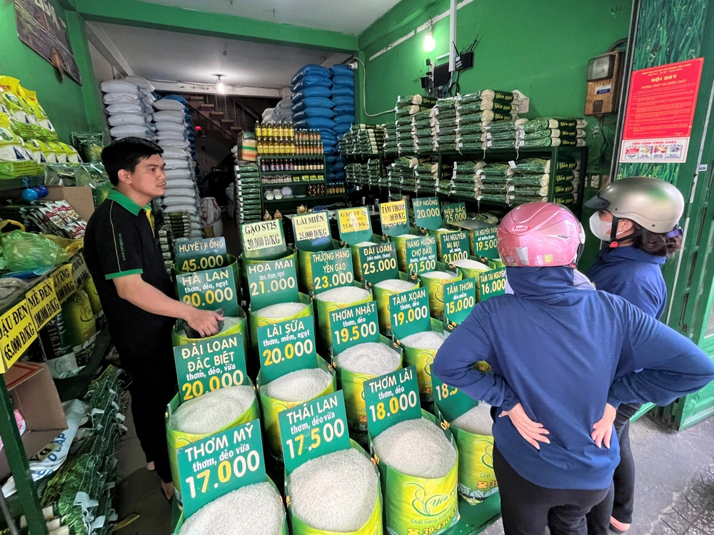 Người tiêu dùng chọn mua gạo tại một cửa hàng quận Tân Bình. Ảnh: TÚ UYÊN