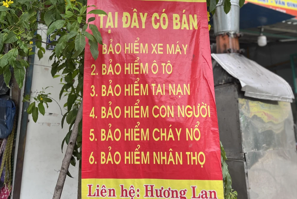 Một cửa hàng treo băng rôn bán các loại bảo hiểm. Ảnh: TÚ UYÊN