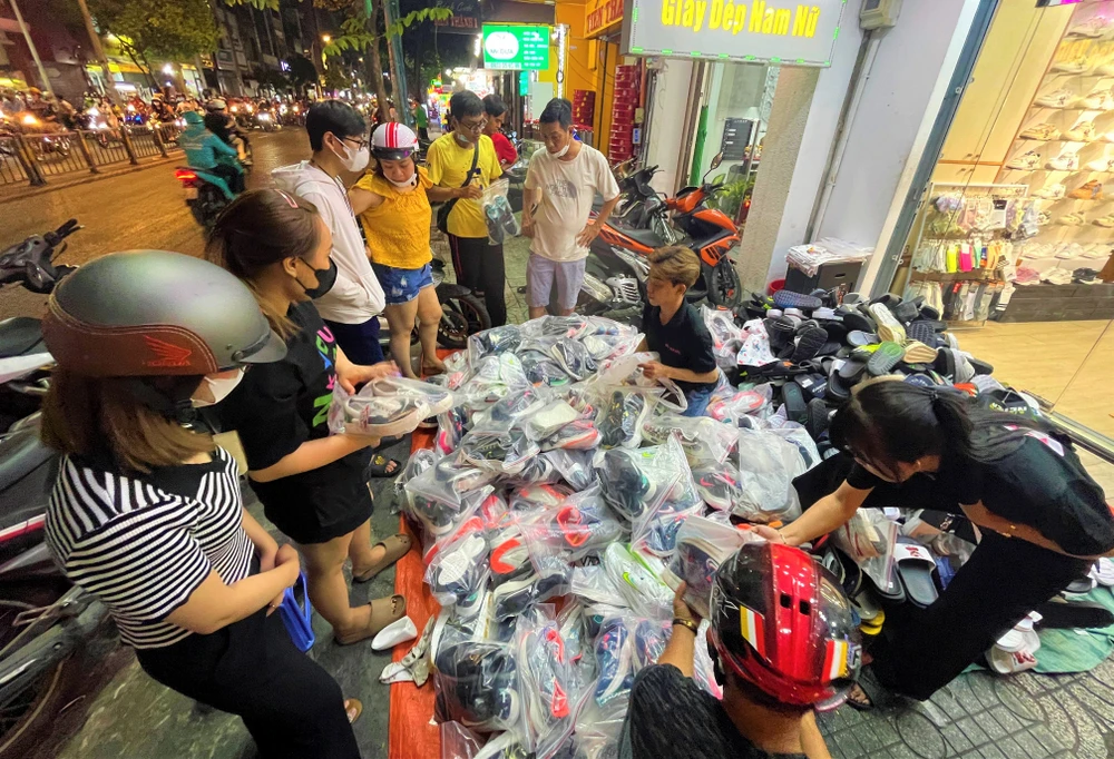 Điểm bán trên đường Cách Mạng Tháng Tám, quận Tân Bình xả dép 99k được nhiều người mua sắm.