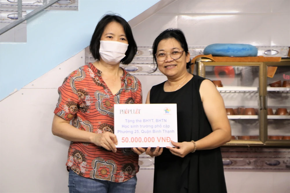 Chị Nguyễn Thị Thanh Trang (Chủ tịch công đoàn báo Pháp Luật TP.HCM) đại diện trao tặng 50.000.000 đồng. Ảnh: HUỲNH THƠ.