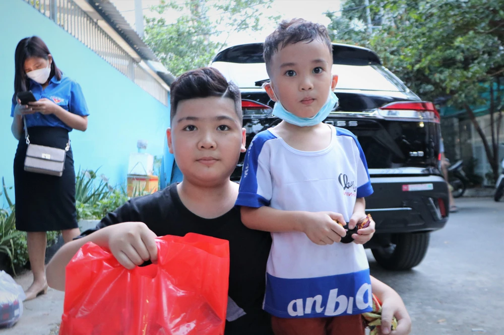 Em Lê Huy Vương 11 tuổi (phải) và Võ Hoàng Xuân Bảo 5 tuổi (trái) tỏ ra thích thú khi được nhận quà. Ảnh: HUỲNH THƠ.