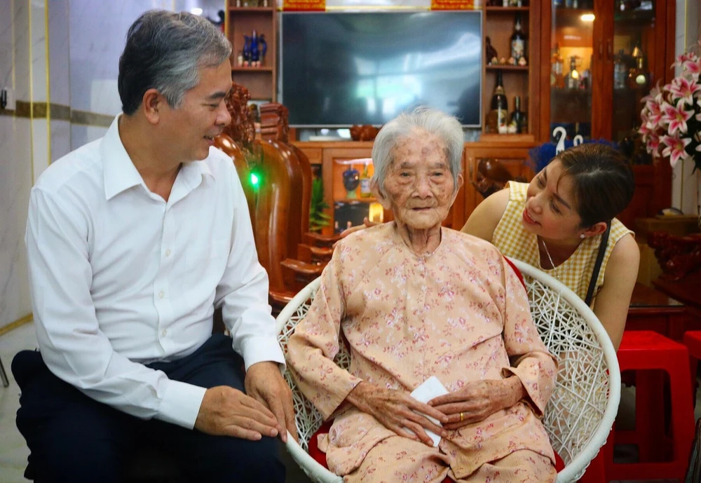 Ông Ngô Minh Châu, Phó Chủ tịch UBND TPHCM thăm hỏi mẹ Việt Nam anh hùng Trịnh Thị Dấu. Ảnh: TÚ NGÂN.