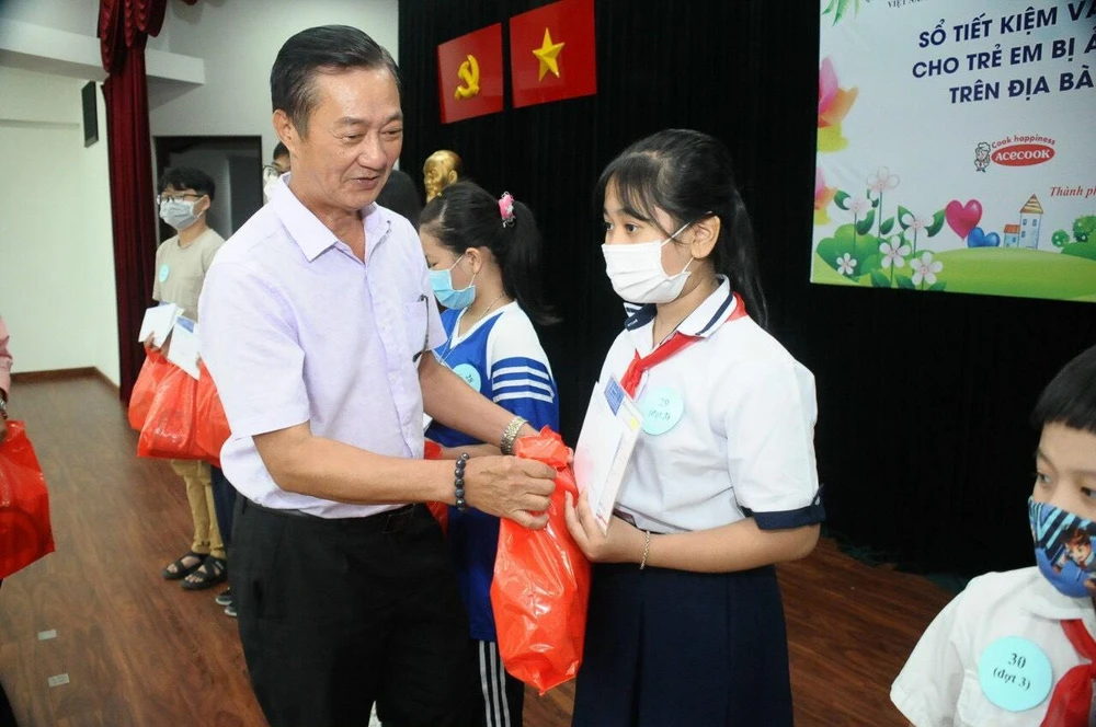 Đại diện Sở LĐ - TBXH trao tặng sổ tiết kiệm và quà trung thu đến tay các em.