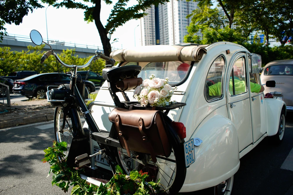 Độc đáo với một chiếc xe gắn máy cổ sản xuất từ thế kỷ 20 được treo phía sau xe của đoàn diễu hành thu hút sự chú ý của người dân...