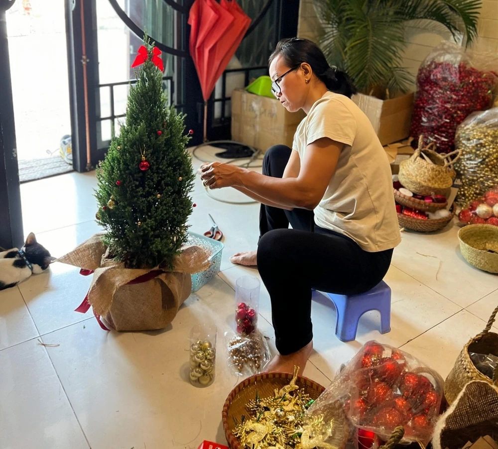 Nhiều loại phụ kiện được lựa chọn trang trí cây thông tươi mini như: trái châu, tuần lộc vàng, đèn led... bắt mắt đáp ứng thị hiếu giới trẻ. Ảnh: TÚ NGÂN