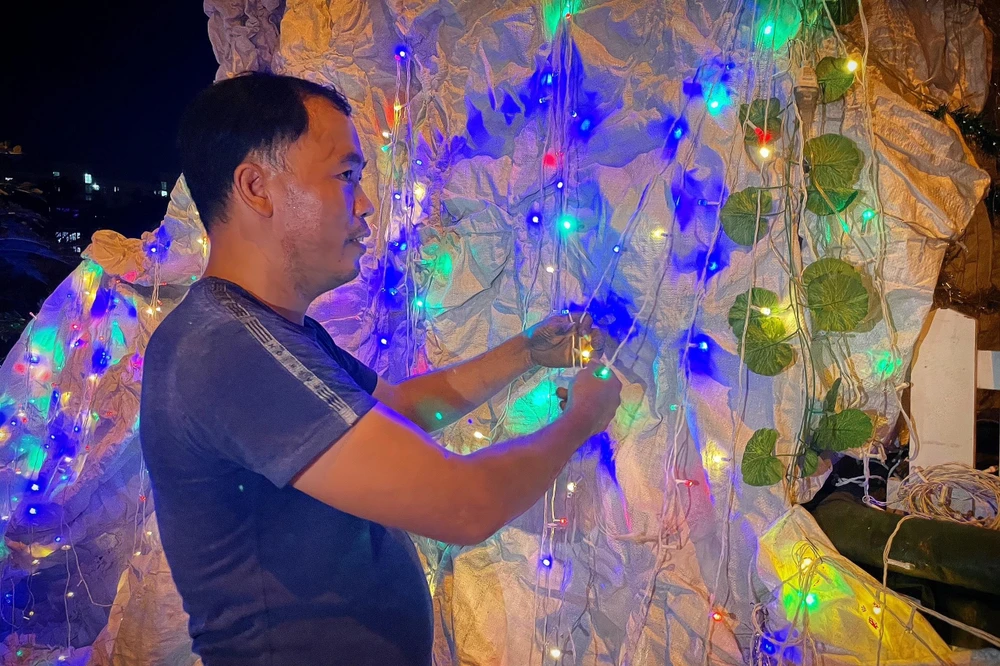 Anh Nguyễn Văn Tý đang kiểm tra lại các thiết bị đèn điện của hang đá.