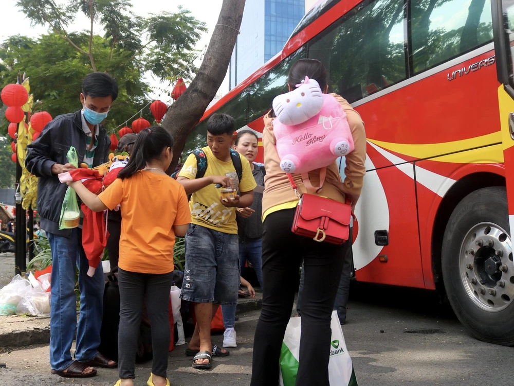 Người lao động di chuyển ra xe về quê đón Tết. Ảnh: TÚ NGÂN