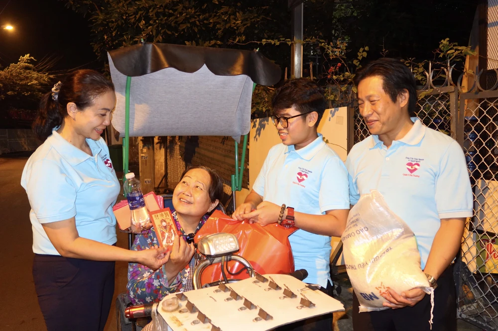 Bà Lê Thị Nhánh vui mừng khi nhận được quà Tết và bao lì xì chúc sức khỏe. Ảnh: TRẦN MINH