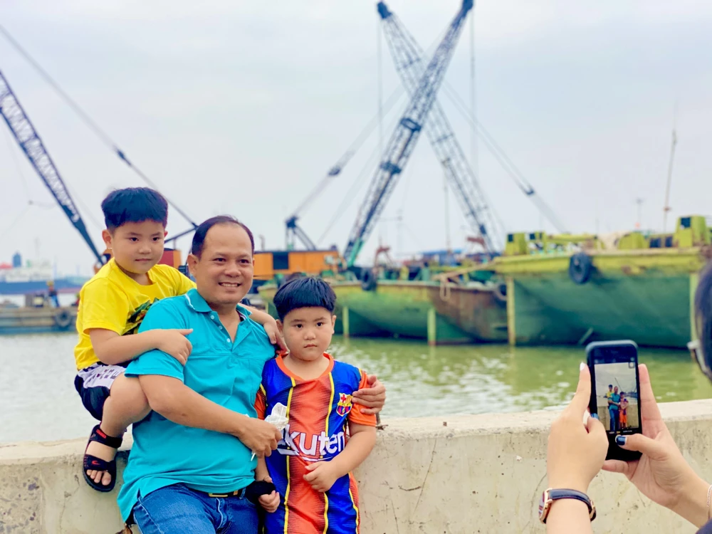 Anh Nguyễn Văn Bảy cùng hai con trai chụp ảnh lưu niệm tại chùa. Ảnh: T.N