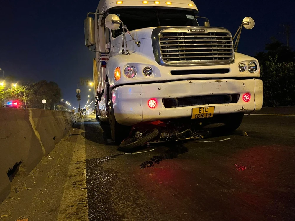 Xe máy bị xe container cuốn vào gầm và kéo lê hàng chục mét. Ảnh: CM