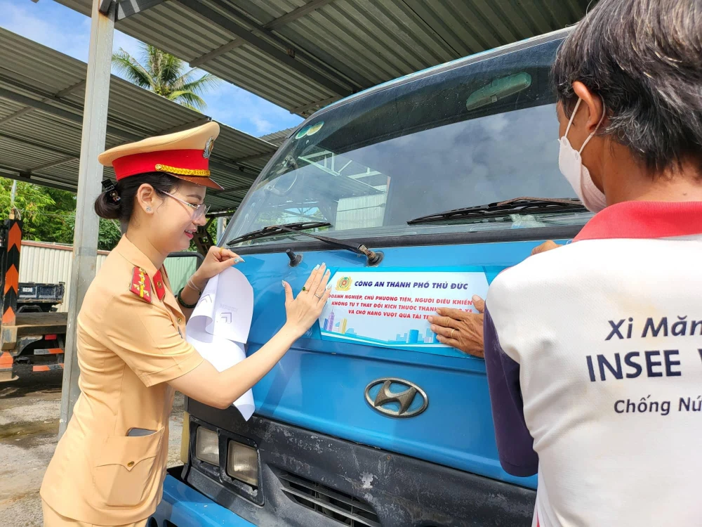 Công an TP Thủ Đức dán khẩu hiệu tuyên truyền trên các xe. Ảnh: TỰ SANG