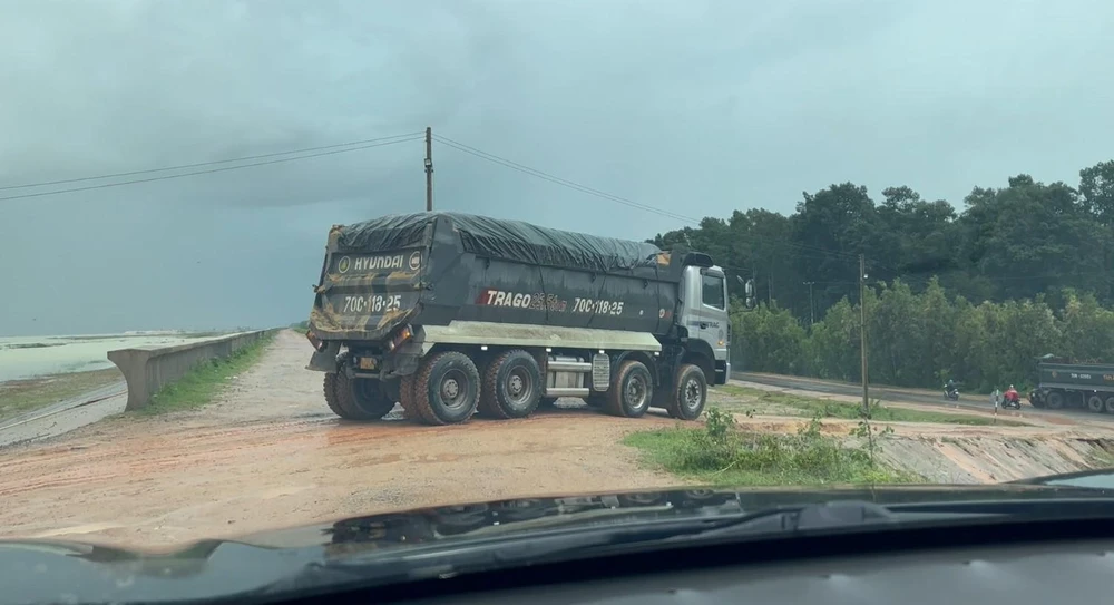 Xe chở cát vun cao quá thùng lưu thông qua thành đập Dầu Tiếng. Ảnh: VÕ TÙNG - TỰ SANG