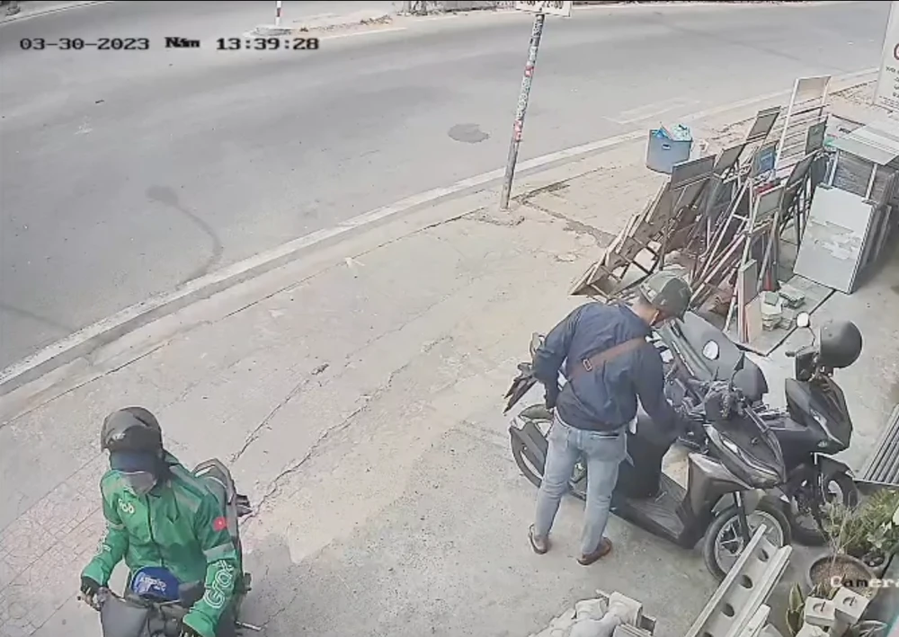 Kẻ trộm đang phá khoá để trộm xe máy. Ảnh: Cắt từ clip