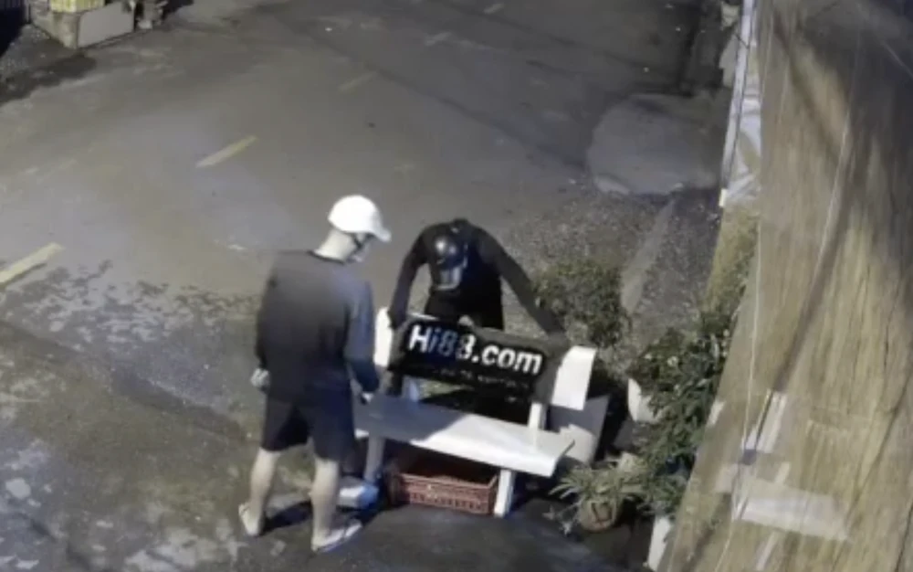 Camera nhà dân ghi lại lúc Quí và Được xịt sơn quảng cáo. Ảnh: Cắt từ clip